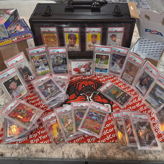 Collection of sports trading cards with a black case on a table.